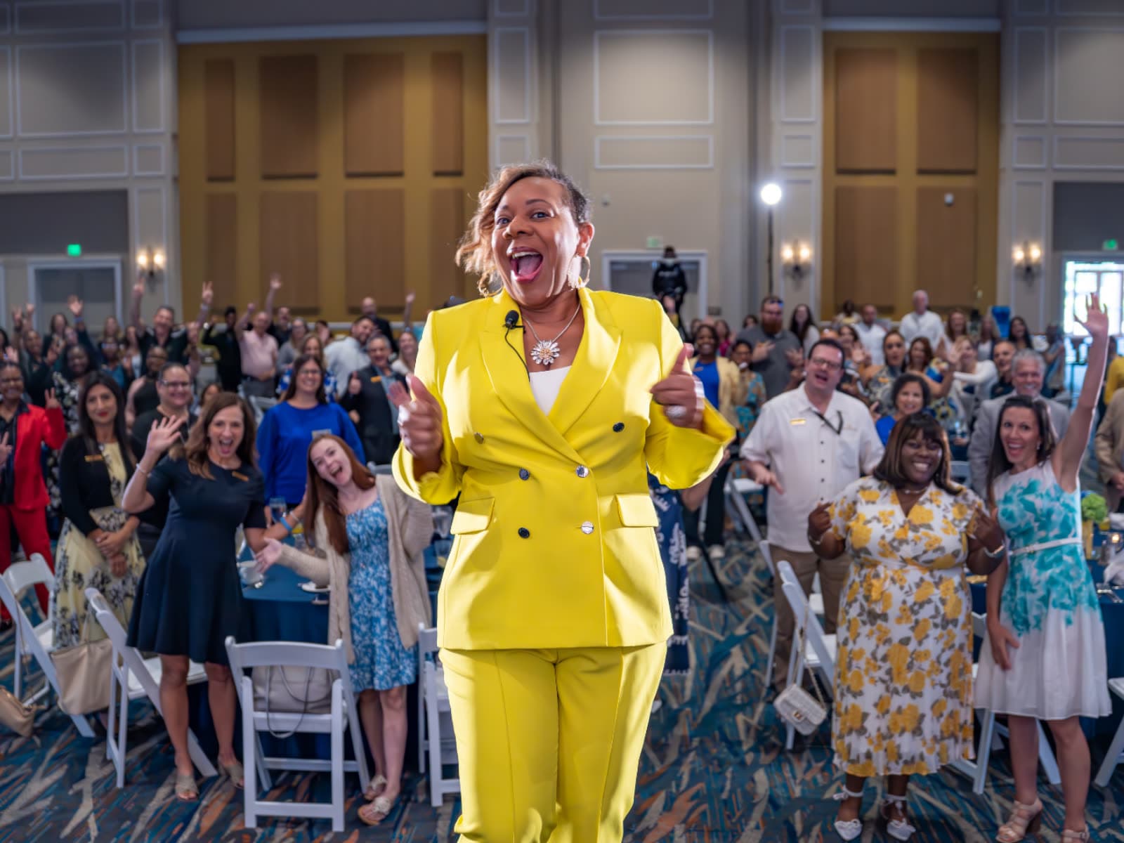 Kelly Charles-Collins, Esq. with a cheering conference ballroom audience